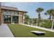 Well-maintained backyard area with lawn game, outdoor patio, and lush tropical foliage at 1836 Sandy Park Trl, Kissimmee, FL 34747
