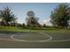 Outdoor basketball court with well maintained green space surrounded by large trees at 1836 Sandy Park Trl, Kissimmee, FL 34747