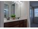 Bathroom with dual sinks, brown cabinets, framed mirror, and decorative accents, creating a functional and stylish space at 1836 Sandy Park Trl, Kissimmee, FL 34747