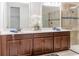 Bathroom with dual sinks, white countertop, dark cabinets, and a tiled shower at 1836 Sandy Park Trl, Kissimmee, FL 34747