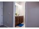 Bathroom featuring a single sink vanity with brown cabinets and a blue bath mat, offering functionality and comfort at 1836 Sandy Park Trl, Kissimmee, FL 34747