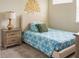 Inviting bedroom with a plush headboard, stylish blue patterned bedding, and a wooden nightstand at 1836 Sandy Park Trl, Kissimmee, FL 34747