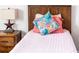 Cozy bedroom featuring a wood headboard, vibrant pillows, and a quaint nightstand with unique decor at 1836 Sandy Park Trl, Kissimmee, FL 34747
