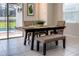 Cozy dining area features a table, chairs, bench, and views of the outdoor space, creating a welcoming ambiance at 1836 Sandy Park Trl, Kissimmee, FL 34747