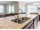 Modern kitchen island with granite countertops, stainless steel sink, and fixtures, offering plenty of space for dining and entertaining at 1836 Sandy Park Trl, Kissimmee, FL 34747