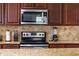 Close-up of modern kitchen appliances and finishes, with granite countertops and designer backsplash at 1836 Sandy Park Trl, Kissimmee, FL 34747