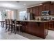 Kitchen with dark wood cabinets, stainless steel appliances, and a granite countertop island at 1836 Sandy Park Trl, Kissimmee, FL 34747