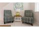 Cozy seating area with stylish striped chairs, decorative artwork, and a side table at 1836 Sandy Park Trl, Kissimmee, FL 34747