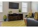 Comfortable living room with decorative rug, entertainment system and black leather couch at 1836 Sandy Park Trl, Kissimmee, FL 34747