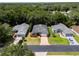 Aerial view of homes with trees, green lawns, and a paved driveway at 2085 Friar Tuck Ln, Orange City, FL 32763