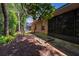 A serene backyard with a brick house, mature trees, and a black fence at 2085 Friar Tuck Ln, Orange City, FL 32763