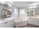 Bright bathroom featuring double vanity, a soaking tub, and glass-enclosed shower at 2085 Friar Tuck Ln, Orange City, FL 32763