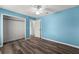 Blue bedroom with wood-look floors and a standard closet at 2085 Friar Tuck Ln, Orange City, FL 32763