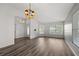 Open-concept living area with high ceilings, laminate flooring, large windows, and decorative chandelier at 2085 Friar Tuck Ln, Orange City, FL 32763