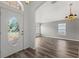 Bright living room with laminate flooring, decorative front door and arched doorway entrance at 2085 Friar Tuck Ln, Orange City, FL 32763