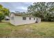 The backyard with partial home view featuring brick finish, green grass and shade trees at 2311 Olivet Ave, Leesburg, FL 34748