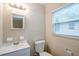 Bathroom featuring a single sink vanity, toilet and a window for natural light at 2311 Olivet Ave, Leesburg, FL 34748