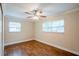 Bedroom with wood-look floors, neutral walls, ceiling fan and two windows at 2311 Olivet Ave, Leesburg, FL 34748