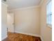 Bedroom featuring wood-look floors, neutral walls, white trim, and a window at 2311 Olivet Ave, Leesburg, FL 34748