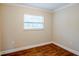 Cozy bedroom with wood-look floors and a window for natural light at 2311 Olivet Ave, Leesburg, FL 34748