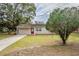 Single-story home showcasing a well-manicured lawn and mature trees at 2311 Olivet Ave, Leesburg, FL 34748