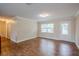 Bright living room with wood-look flooring, crown molding, and a decorative glass front door at 2311 Olivet Ave, Leesburg, FL 34748