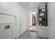 Utility room with white walls, mechanical closet, and a view into the kitchen featuring stainless steel appliances at 2311 Olivet Ave, Leesburg, FL 34748