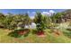 Backyard featuring a variety of trees, a white fence, and a view of the serene lake at 2506 Shelby Cir, Kissimmee, FL 34743