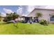 Lush backyard with manicured lawn, mature trees, and covered patio, ideal for outdoor living at 2506 Shelby Cir, Kissimmee, FL 34743