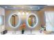 Bathroom featuring dual vanities, lighted mirrors, and under cabinet storage at 2506 Shelby Cir, Kissimmee, FL 34743