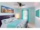 Bright bedroom featuring coastal-themed décor, ceiling fan, and natural light from the window at 2506 Shelby Cir, Kissimmee, FL 34743