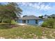 Spacious backyard with a patio, set against a vibrant blue house exterior and blue skies at 2963 Beckwith St, Deltona, FL 32738