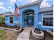 Welcoming entrance with American flag, decorative plants, and blue painted facade at 2963 Beckwith St, Deltona, FL 32738
