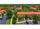 Aerial view of a colorful townhome community with lush landscaping, mature trees, and ample parking at 3002 Secret Lake Dr, Kissimmee, FL 34747