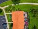 Aerial view of a home featuring a screened-in lanai, tiled roof, lush landscaping, and parking at 3002 Secret Lake Dr, Kissimmee, FL 34747