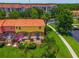 Aerial view of a vibrant townhouse with a screened lanai, lush landscaping, and community surroundings at 3002 Secret Lake Dr, Kissimmee, FL 34747