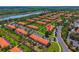 Community of townhomes with red tile roofs, lush lawns, and trees at 3002 Secret Lake Dr, Kissimmee, FL 34747