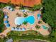 Aerial view of community pool with shaded lounge chairs and surrounding greenery at 3002 Secret Lake Dr, Kissimmee, FL 34747