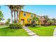 Brightly painted townhome with well-kept lawn, shrubbery, and walking path to the front door at 3002 Secret Lake Dr, Kissimmee, FL 34747