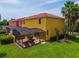 Yellow townhome with screened patio, lush lawn, and tropical landscaping at 3002 Secret Lake Dr, Kissimmee, FL 34747