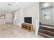 Hallway with hardwood-style floors, TV console, and staircase at 3002 Secret Lake Dr, Kissimmee, FL 34747