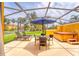 A private screened patio with lounge chairs, an umbrella table and a hot tub, perfect for enjoying the outdoors at 3002 Secret Lake Dr, Kissimmee, FL 34747