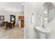 Stylish powder room featuring a pedestal sink, modern fixtures, and easy access to the dining and kitchen areas at 3002 Secret Lake Dr, Kissimmee, FL 34747