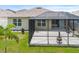 Spacious backyard featuring a screened-in lanai, well-maintained lawn, and lush landscaping at 341 Alexzander Way, Winter Haven, FL 33881