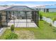 Aerial view of the backyard, including a screened-in porch, white fence, and well-maintained landscaping at 341 Alexzander Way, Winter Haven, FL 33881