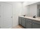 This bathroom features double sinks, gray cabinets and modern fixtures at 341 Alexzander Way, Winter Haven, FL 33881