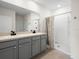 Modern bathroom featuring double sinks, grey cabinets, and a shower with a curtain at 341 Alexzander Way, Winter Haven, FL 33881