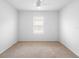 Empty carpeted bedroom featuring a window, neutral walls, and ceiling fan at 341 Alexzander Way, Winter Haven, FL 33881