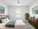 Staged bedroom features a ceiling fan, queen bed, and natural light from window at 341 Alexzander Way, Winter Haven, FL 33881