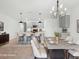 Open-concept dining area featuring modern chandelier, island seating, and gray cabinets at 341 Alexzander Way, Winter Haven, FL 33881